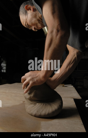 Side profile of a potter kneading clay Stock Photo