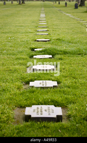 Graves each containing a number of soldiers remains at German military cemetery at La Cambe Normandy France Stock Photo