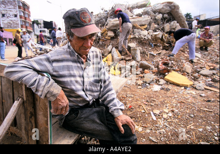 Earthquake in Colombia 1999  -  old man takes a rest while people continue to pick through remains in Armenia Stock Photo