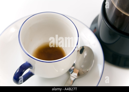 close up view of a used empty coffee cup with part full cafetiere Stock Photo