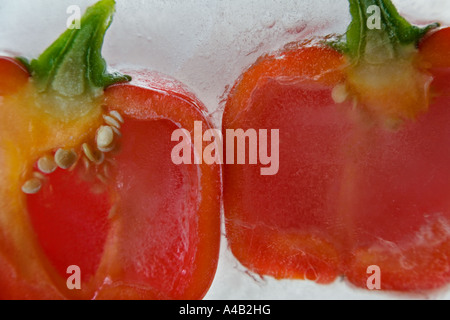 Close-up of two red pepper halves showing the inside with seeds frozen in ice Stock Photo