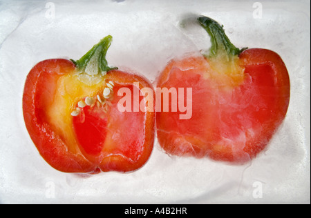 Close-up of two red pepper halves showing the inside with seeds frozen in ice Stock Photo