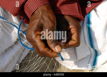 Stock image of Indian tribal fishermans hands fishers repairing their fishing nets near Chennai Tamil Nadu India Stock Photo