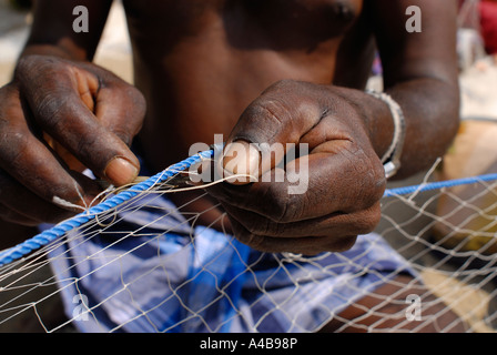 Stock image of Indian tribal fishermans hands fishers repairing their fishing nets near Chennai Tamil Nadu India Stock Photo