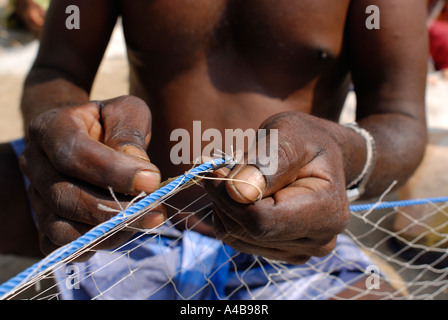 Stock image of Indian tribal fishermans hands fishers repairing their fishing nets near Chennai Tamil Nadu India Stock Photo