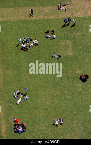 People relaxing on grass in park below the Eiffel Tower Paris France Stock Photo