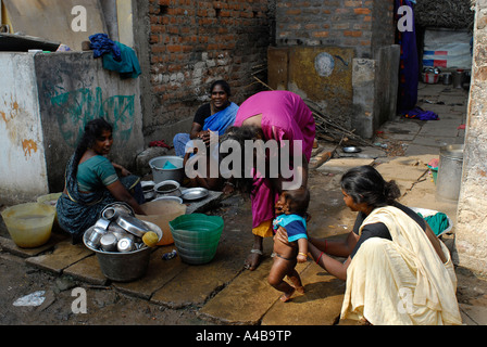 Stock Image of Dalit mother bathing baby boy at community well in the Jagathapuram slum in Chennai Tamil Nadu India Stock Photo