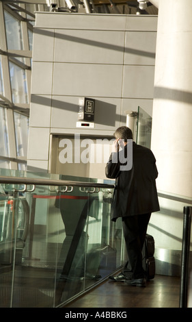 Man using cell phone whilst waiting in the airport Stock Photo