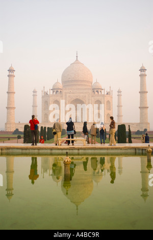 Stock Image of the Taj Majal in Agra India at sunrise with reflections in pool with tourists Stock Photo