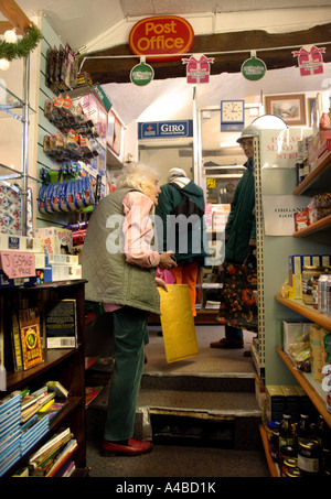 PENSIONERS QUEUE AT A VILLAGE SHOP AND POST OFFICE AT MONKTON FARLEIGH WILTSHIRE UK Stock Photo