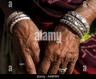 Ninety year old Rajasthan woman her weathered hands and bangles in sari with head covering Stock Photo