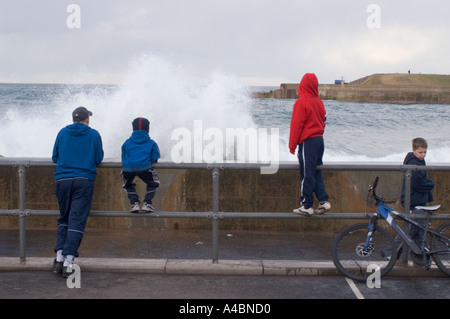 Waves break over Eyemouth beach wall North Sea fishing port Scottish Borders UK Stock Photo