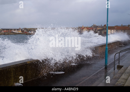 Waves break over Eyemouth beach wall North Sea fishing port Scottish Borders UK Stock Photo