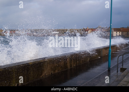Waves break over Eyemouth beach wall North Sea fishing port Scottish Borders UK Stock Photo