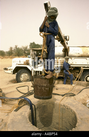 Workmen dig a new well, paid for by an NGO, lined with coriggated iron for a drought stricken Agelock village, Mali Stock Photo