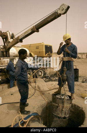 Workmen dig a new well, paid for by an NGO lined with coriggated metal for a drought stricken village,  Agelock Mali Stock Photo