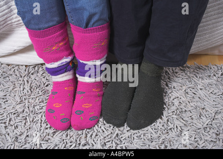 Couple sitting on sofa wearing socks Stock Photo