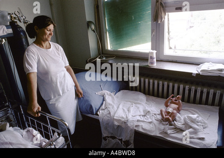 Vukovar, Croatia, under Serb control,  Sept 1992 :  A  nurse smiles at a new-born baby in the town's hospital. Stock Photo