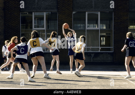 TEENAGE SCHOOL GIRLS PLAYING NETBALL IN PLAYGROUND AT GLASGOW HOLYROOD SECONDARY SCHOOL. MAY 1990. Stock Photo