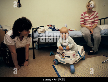 An inmate spends time with her baby son  under the watch of a prison officer.' Stock Photo