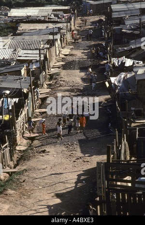 Residents walk along the path between shacks at the Casa Verde land invasion Sao Paulo Brazil Stock Photo