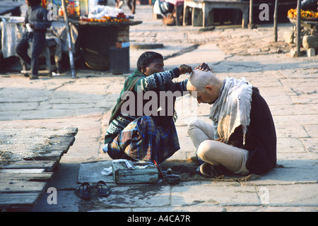 young man getting his head shaved, varanasi, india Stock Photo