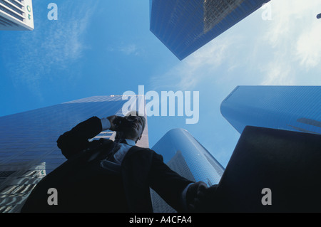 Businessman with cellphone and briefcase walking through Los Angeles downtown Civic Center Stock Photo