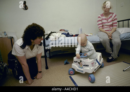 An inmate spends time with her baby son  under the watch of a prison officer.' Stock Photo