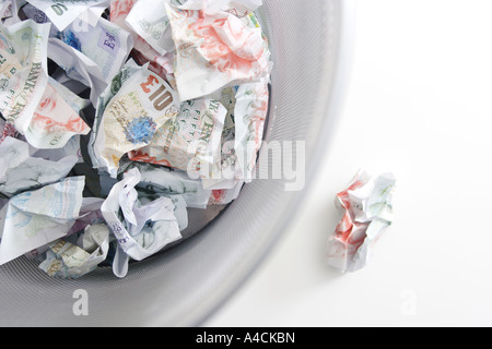 screwed up british currency notes in bin Stock Photo