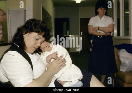 inmate sat with her baby in her arms under the vigilance of the woman prison officer askham grange york Stock Photo