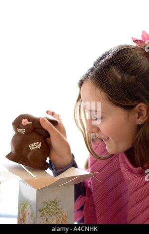 Girl takes chocolate Easter bunny out of gift box Stock Photo