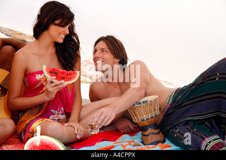 Young couple sitting on beach Stock Photo