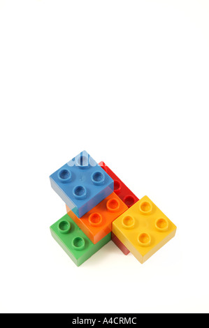 simple construction made from child's lego in studio on clean white surface involving blue orange yellow green and red colors Stock Photo