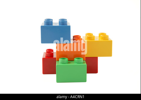conceptual simple construction made from childs lego in studio on clean white surface involving blue orange yellow green and red Stock Photo