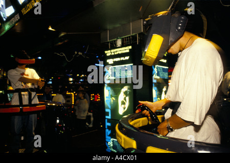 A boy wears a 3D visor to play a virtual reality video game in three dimensions at a games franchise in the Trocadero Centre Stock Photo