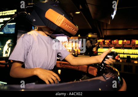 A girl wears a 3D visor to play a virtual reality video game in three dimensions at a games franchise in the Trocadero Centre Stock Photo