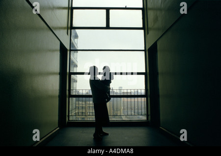 The silhouette of a 17 year old homeless girl with her baby in a corridor in a London building. Stock Photo