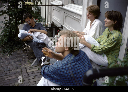2 women and two men sitting on a door step with a new-born baby, Amsterdam, Netherlands Stock Photo