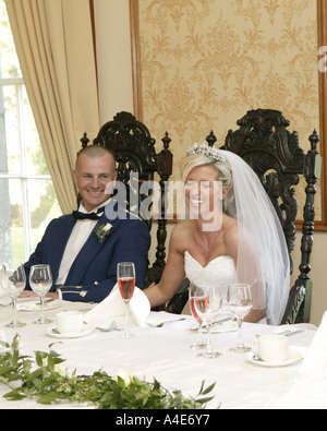 Bride & groom laughing at top table during speeches Stock Photo