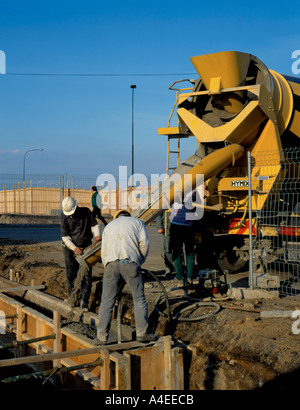 Pouring concrete from a ready mix concrete wagon to form a building foundation. Stock Photo