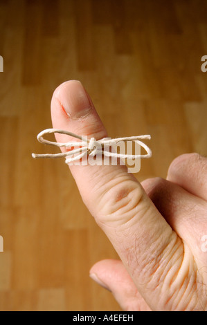 A piece of string tied round a finger as a reminder not to forget something Stock Photo