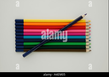 A row of eleven different coloured crayons on a white background Stock Photo