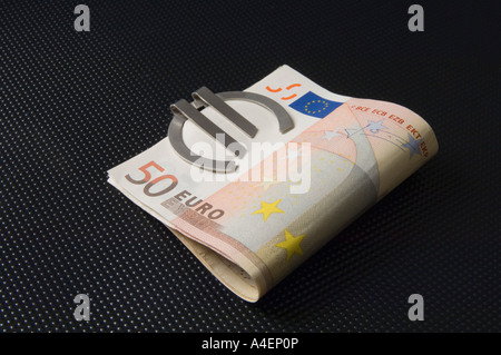 A money clip in the form of a Euro symbol holding 50 Euro banknotes Stock Photo
