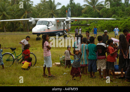 Islanders observe as supplies are unloaded from airplane Majikin island Namu atoll Marshall Islands N Pacific Stock Photo