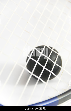 Squash ball against strings of racket with short DOF Stock Photo