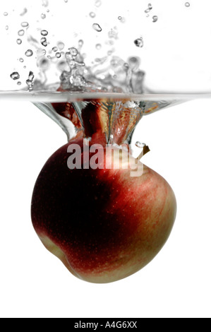 Red apple splashing into water Stock Photo