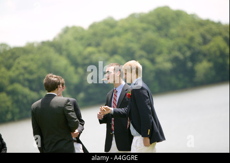 Graduating senior year pupils gather on lawn by lake after Commencement Day ceremony at private high school USA June 2005 Stock Photo