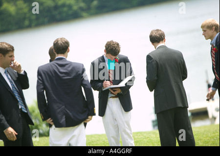 Graduating senior year pupils gather on lawn by lake after Commencement Day ceremony at private high school USA June 2005 Stock Photo