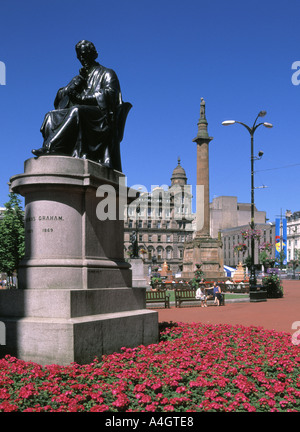Historic George Square Glasgow flowers & statue of chemist Dr Thomas Graham with Sir Walter Scott column & historical City Chambers beyond Scotland UK Stock Photo
