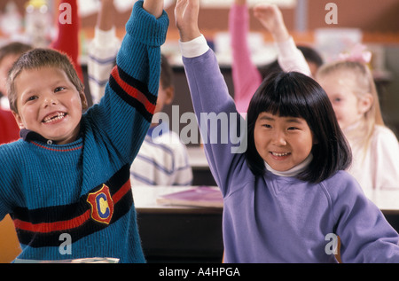 Students raising hands in class Stock Photo